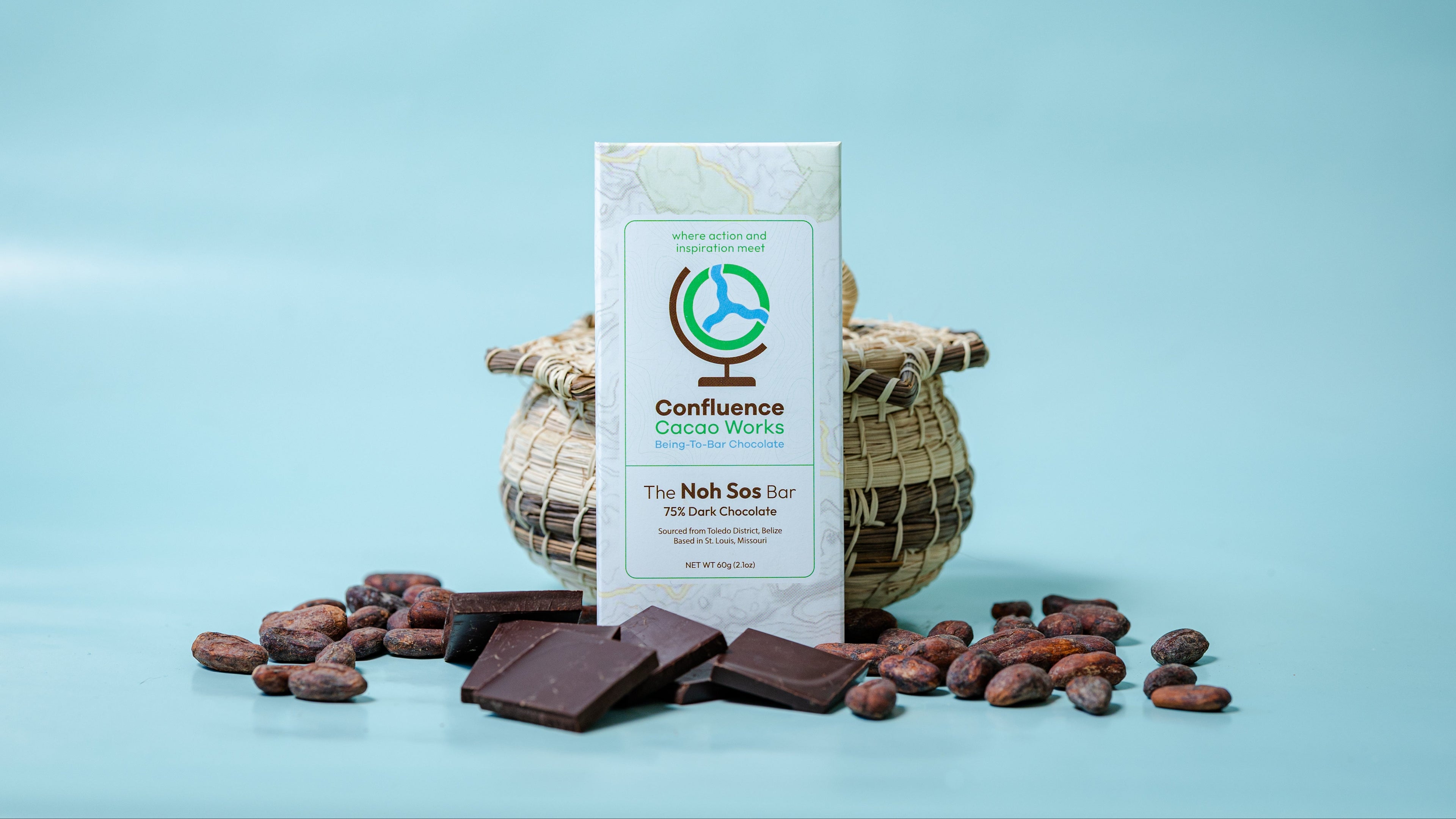 Confluence Cacao Works chocolate bar with cocoa beans on a light blue background